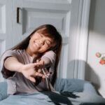 Woman stretching happily as she wakes up, tulips on the nightstand