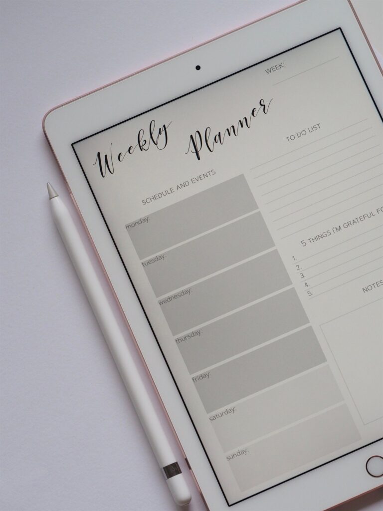 Weekly planner shown on a tablet with a stylus pen